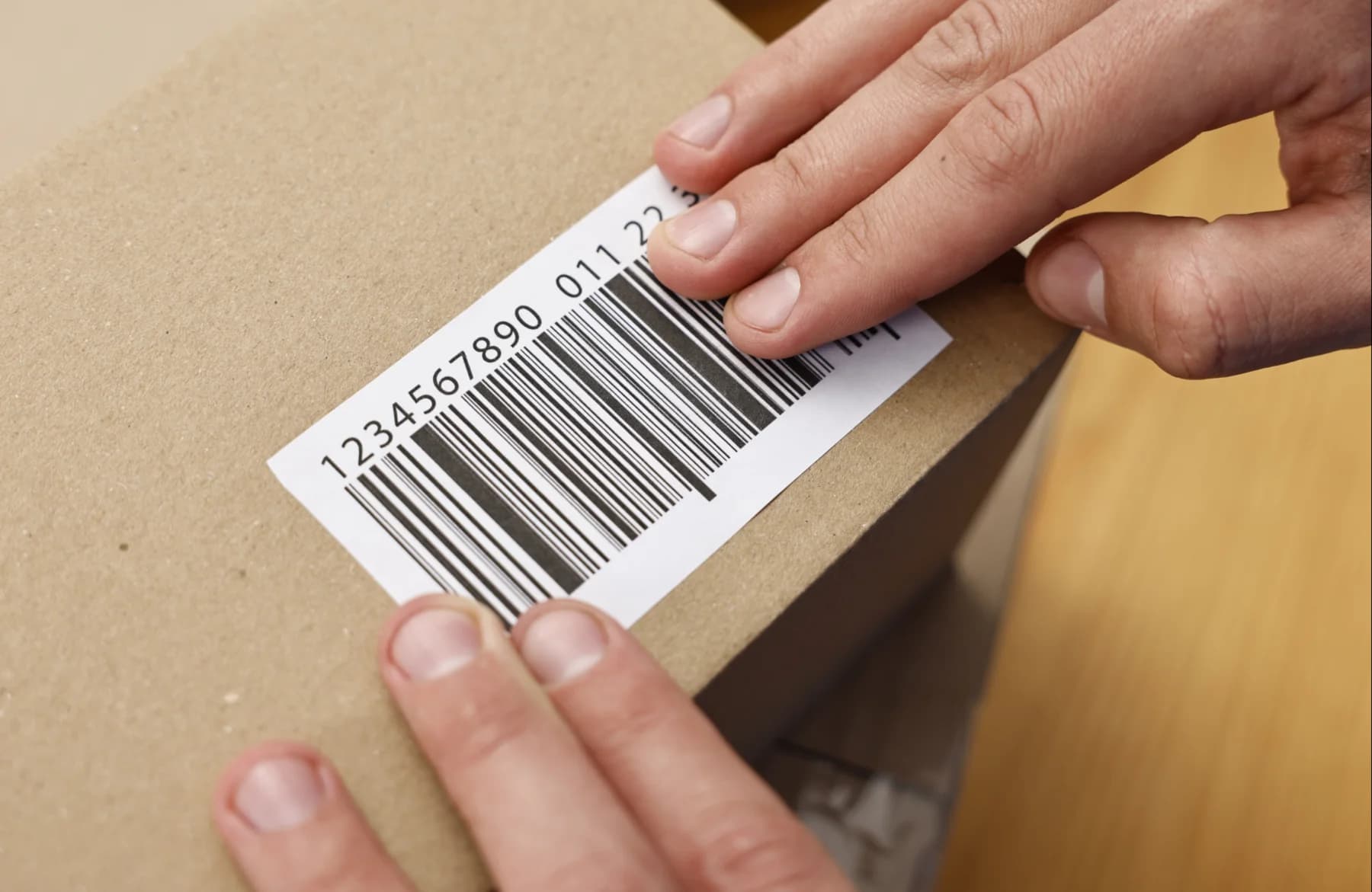 Persona pegando código de barras en caja
