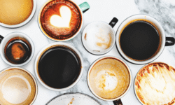 Variedad de tazas de café con diferentes bebidas, bebidas calientes y latte con corazón en la espuma.