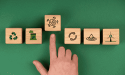 Texto alternativo: Mano tocando bloque con símbolo del reciclaje, conciencia ambiental y sostenibilidad.