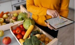 Escaneo de código de barras en alimentos frescos usando tablet en mercado local.